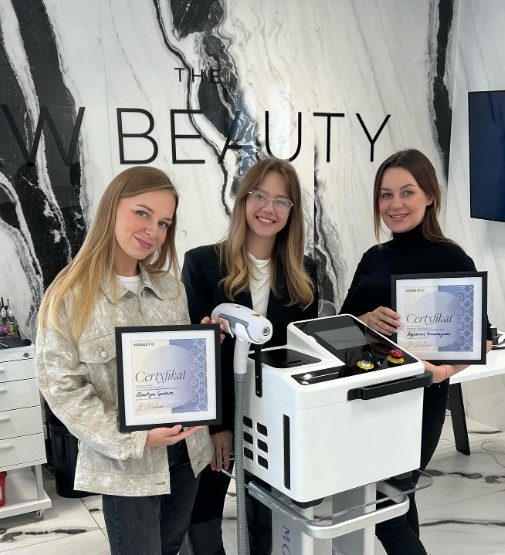 Uczestniczki szkolenia Modestic z certyfikatami przy urządzeniu laserowym w salonie beauty