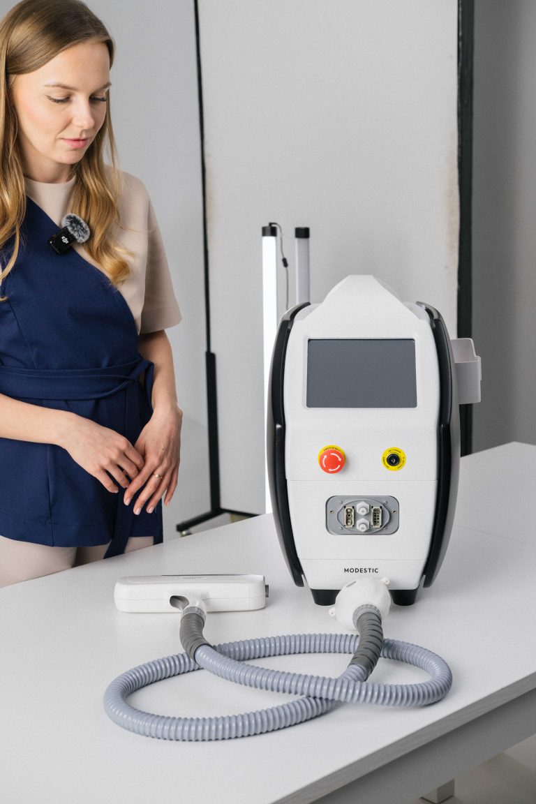Specjalistka w salonie beauty prezentuje urządzenie Modestic Laser Nova do usuwania makijażu permanentnego i tatuaży