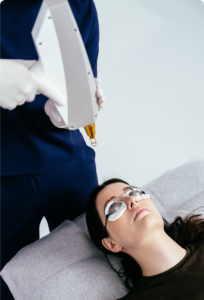 Zabieg laserowego usuwania makijażu permanentnego wykonywany z użyciem lasera Modestic – klientka w okularach ochronnych